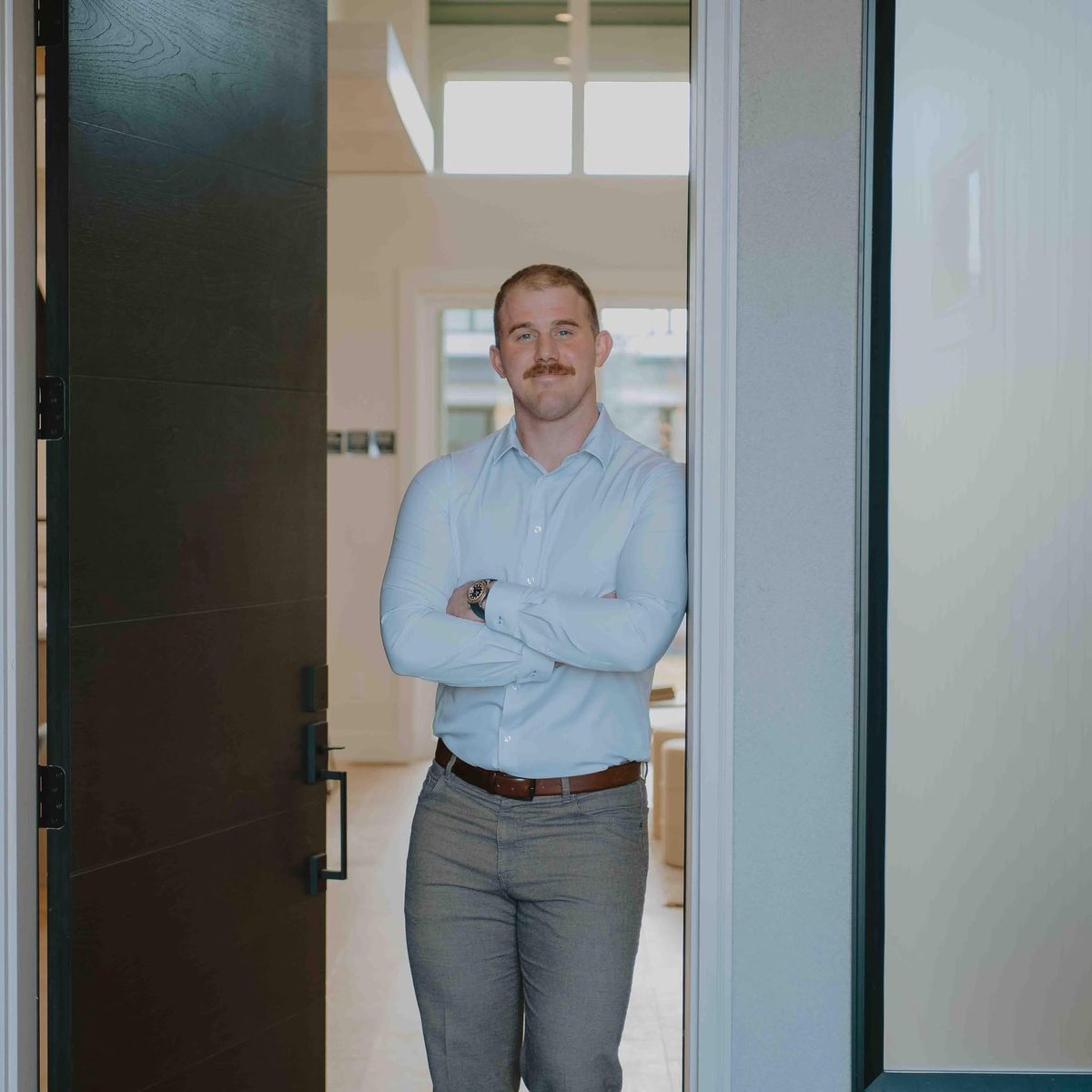 Caleb Lehmann, Arizona REALTOR®, standing in the doorway of a modern home